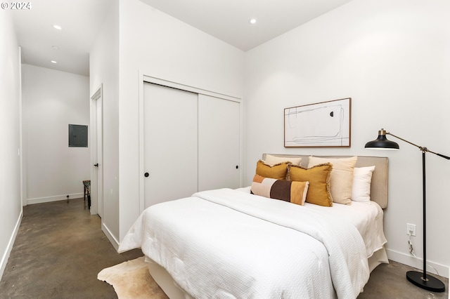 bedroom with recessed lighting, a closet, concrete flooring, electric panel, and baseboards