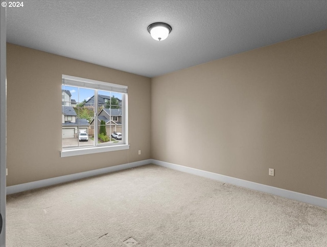 carpeted empty room with a textured ceiling