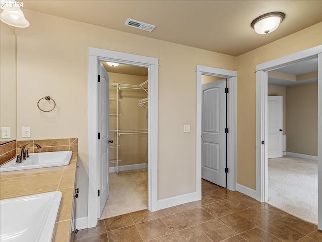 bathroom featuring sink, tile patterned floors, and a washtub