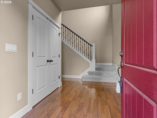 foyer with stairway, baseboards, and wood finished floors