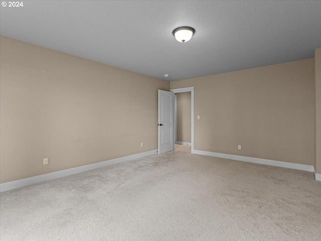 carpeted empty room with a textured ceiling