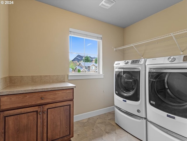 laundry room featuring cabinets and washer and dryer