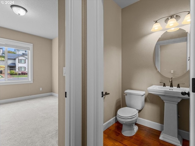 bathroom featuring a textured ceiling, toilet, and hardwood / wood-style floors