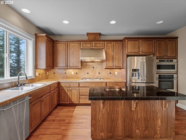 kitchen featuring a kitchen bar, light hardwood / wood-style flooring, stainless steel appliances, and sink