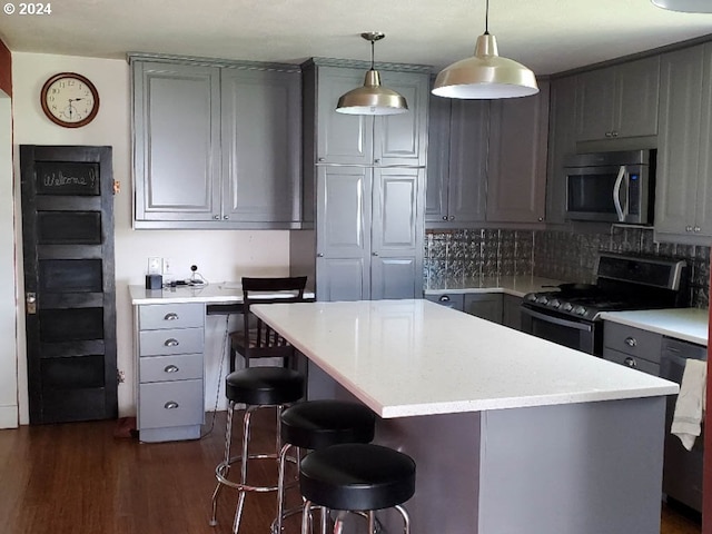 kitchen with decorative backsplash, black range oven, pendant lighting, gray cabinets, and a kitchen island