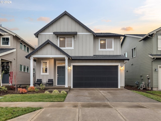 view of front of house with a garage, covered porch, driveway, and board and batten siding