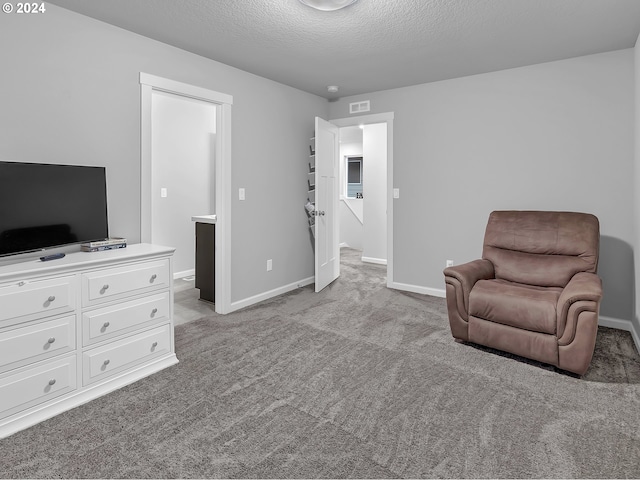 sitting room with light carpet and a textured ceiling