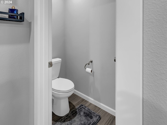 bathroom with wood-type flooring and toilet