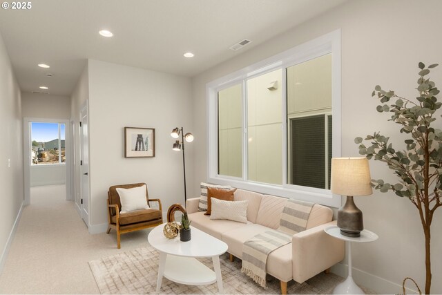 living area with visible vents, recessed lighting, light carpet, and baseboards