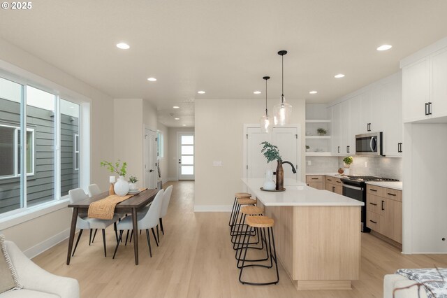 living room with a large fireplace, visible vents, wood finished floors, and baseboards