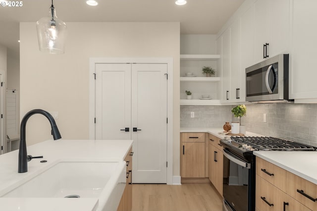 12040 SW Trask St Unit Lt96, Beaverton, OR 97007 - kitchen featuring stainless steel microwave, gas stove, a sink, light brown cabinets, and light wood finished floors