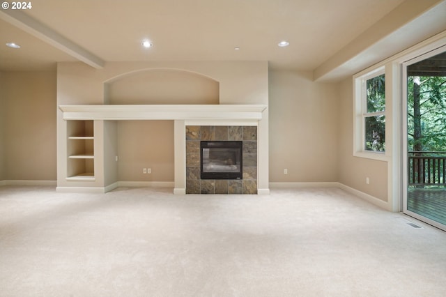 unfurnished living room featuring a tile fireplace and light carpet