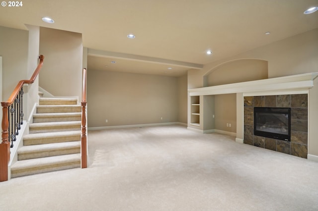 unfurnished living room with a tiled fireplace and light colored carpet