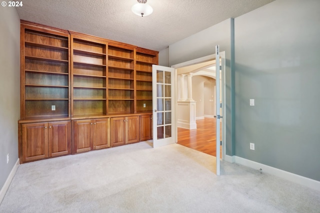 carpeted empty room with a textured ceiling