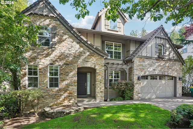 english style home featuring a garage and a front lawn