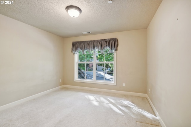 carpeted spare room with a textured ceiling