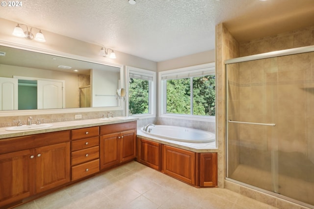 bathroom with vanity, a textured ceiling, plus walk in shower, and tile patterned flooring