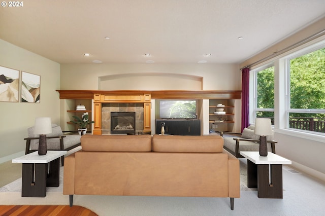 carpeted living room featuring a tiled fireplace