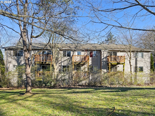 view of front of property with a deck and a front lawn