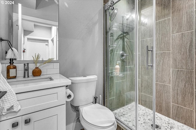 bathroom with vanity, toilet, and a shower with shower door