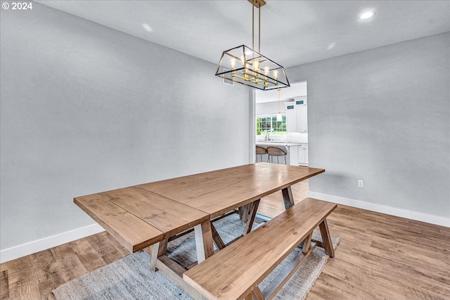 dining space featuring light hardwood / wood-style floors and a notable chandelier