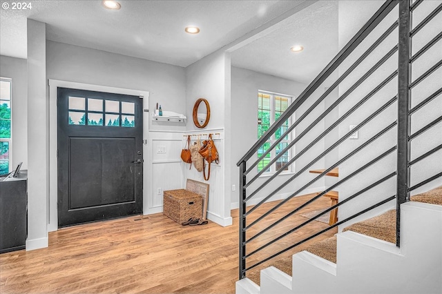 foyer entrance with wood-type flooring and a textured ceiling