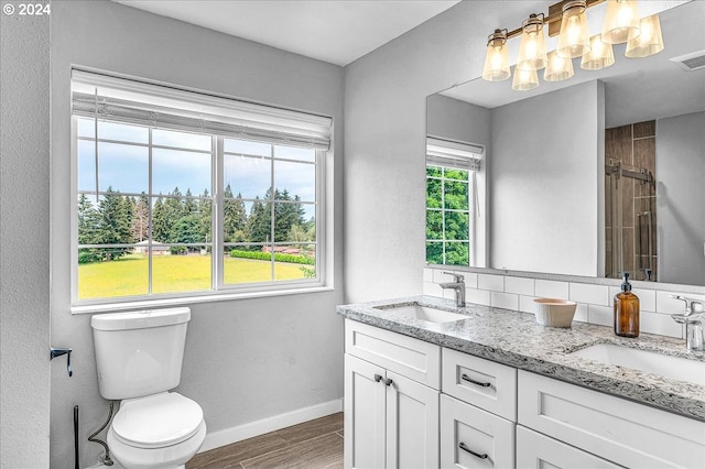 bathroom featuring tiled shower, wood-type flooring, vanity, and a wealth of natural light