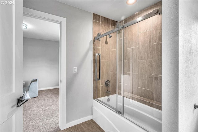 bathroom featuring combined bath / shower with glass door