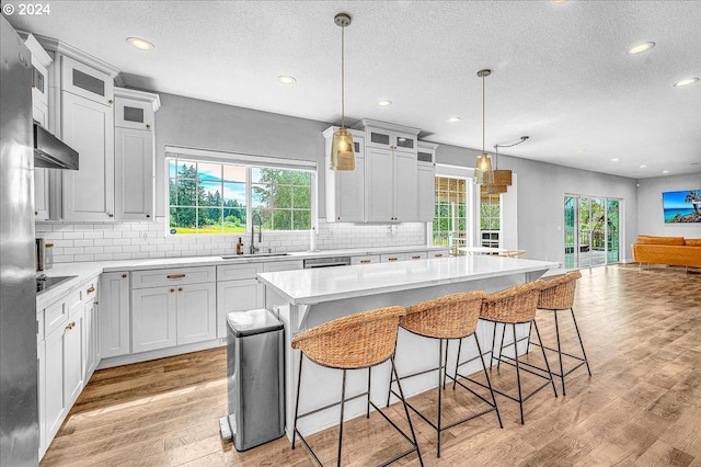 kitchen featuring a kitchen island, a healthy amount of sunlight, and white cabinetry