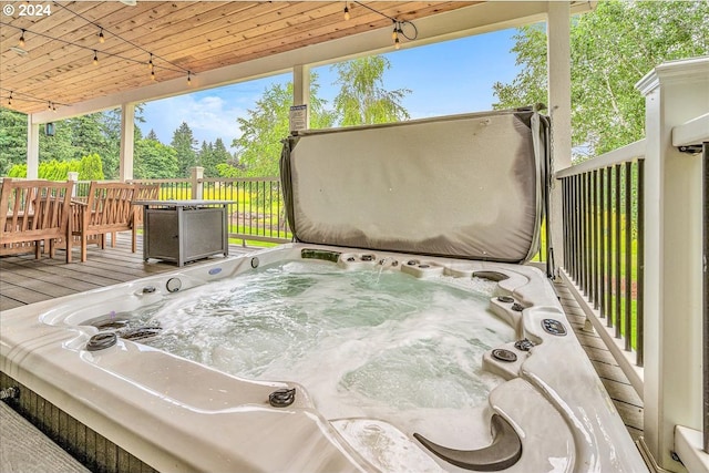 deck featuring a covered hot tub