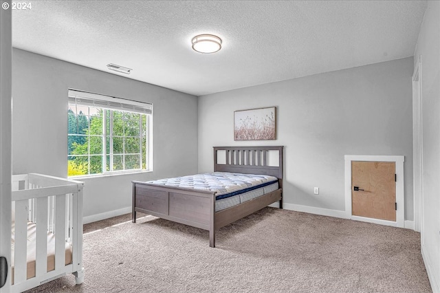 bedroom with light carpet and a textured ceiling