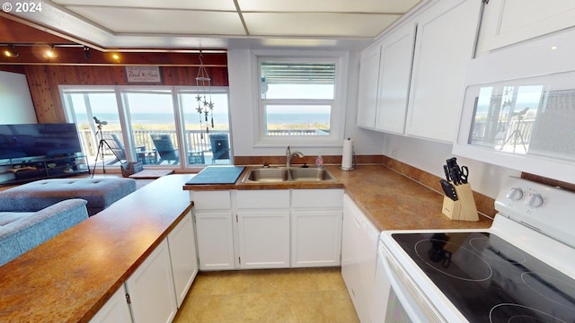 kitchen featuring track lighting, white appliances, sink, light tile patterned floors, and white cabinets