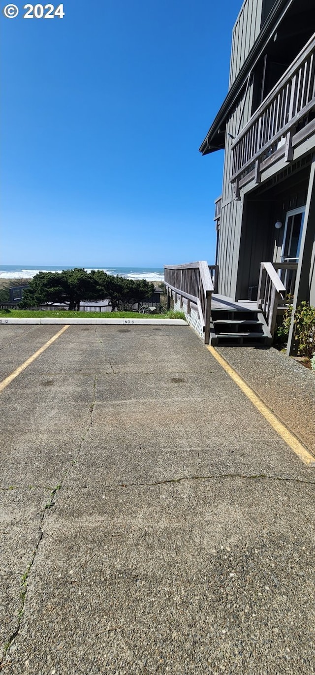 view of car parking featuring a water view