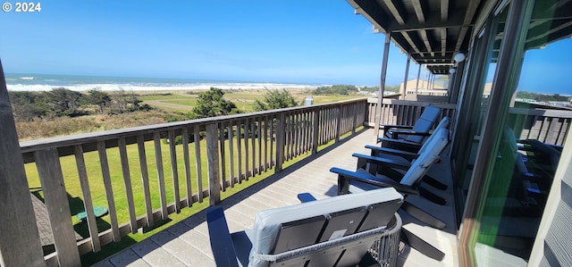 balcony with a water view and a view of the beach