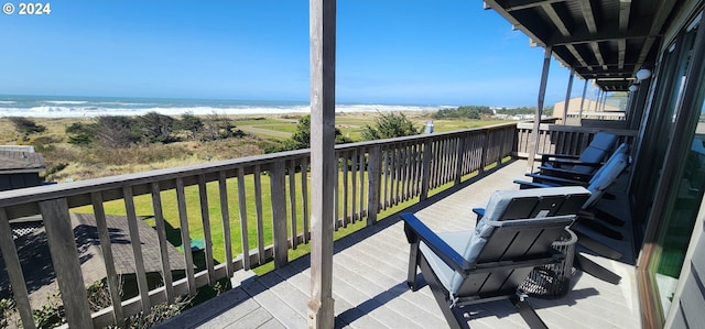 balcony with a water view and a view of the beach