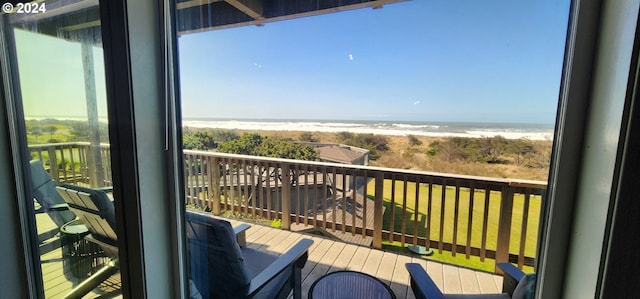 balcony with a water view and a view of the beach