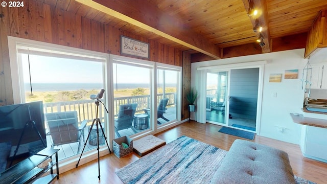 sunroom / solarium featuring beamed ceiling, rail lighting, wooden ceiling, and sink