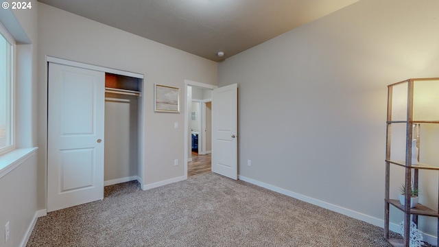 unfurnished bedroom featuring carpet floors, baseboards, and a closet