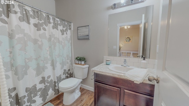 full bath with decorative backsplash, a shower with shower curtain, toilet, vanity, and wood finished floors