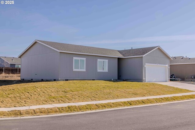 ranch-style home featuring a garage and a front lawn