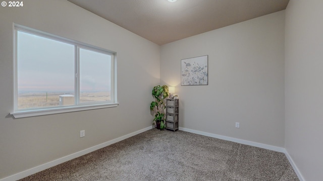 spare room with carpet and baseboards