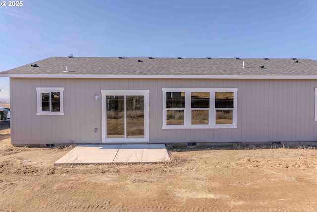 back of house with crawl space, a shingled roof, and a patio