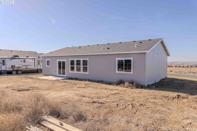 back of property with crawl space and roof with shingles