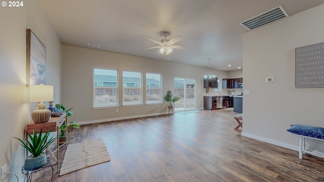 living area with wood finished floors, visible vents, and baseboards