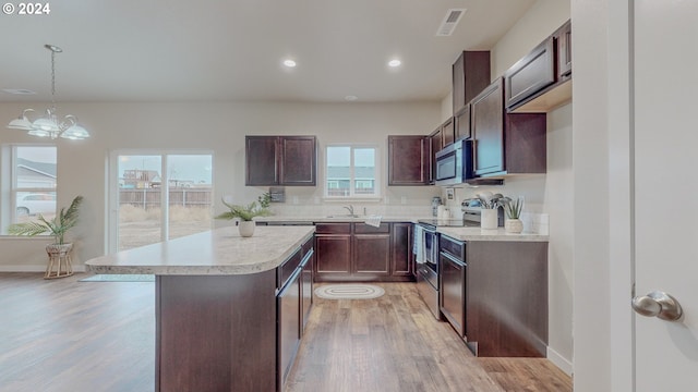 kitchen featuring visible vents, light countertops, appliances with stainless steel finishes, light wood-type flooring, and a center island