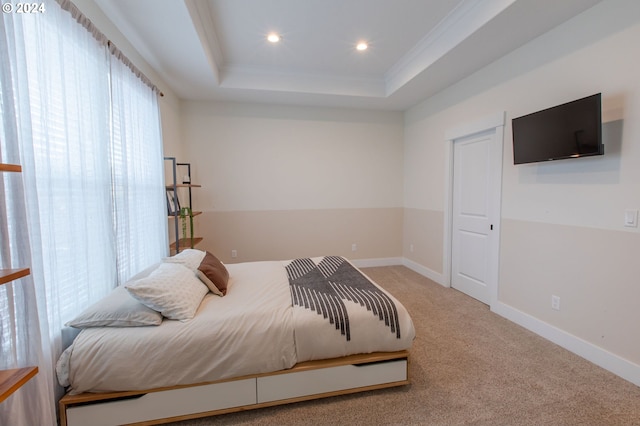 bedroom featuring carpet floors, a raised ceiling, and ornamental molding