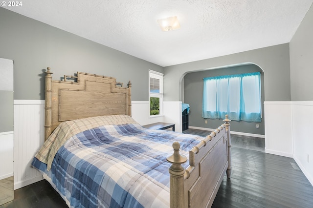 bedroom featuring dark hardwood / wood-style flooring and a textured ceiling