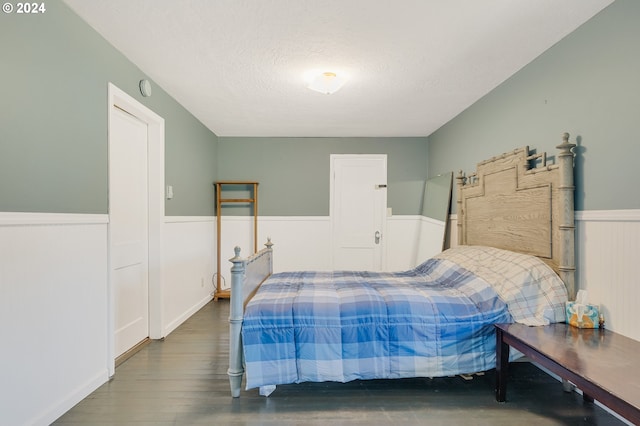 bedroom featuring a textured ceiling and dark wood-type flooring