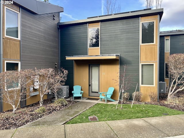 back of house featuring a lawn and ac unit