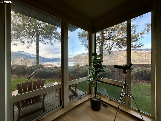 sunroom / solarium featuring plenty of natural light and a water and mountain view